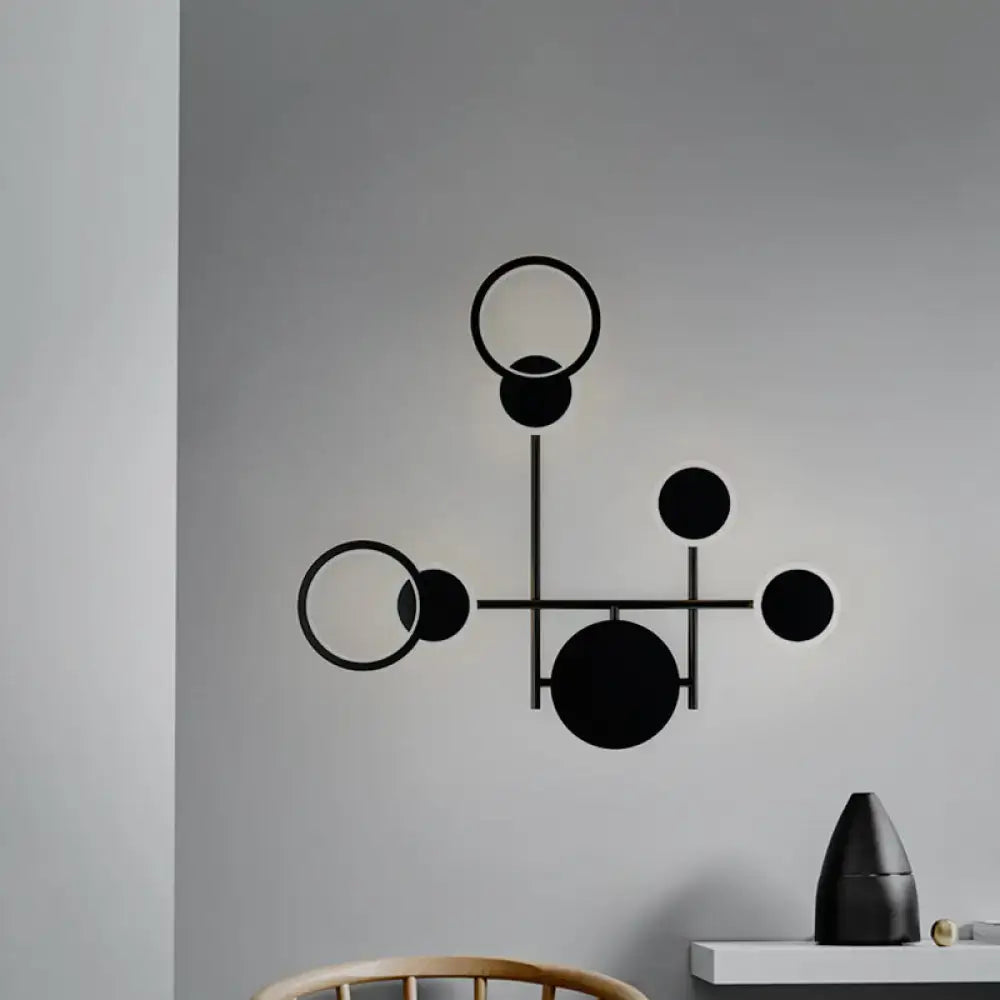 Modern black and white metallic round led wall sconce with black geometric interconnected circles on gray background