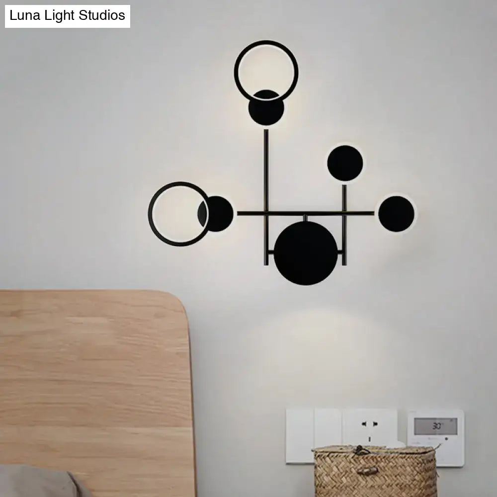 Modern black and white metallic round led wall sconce with geometric circular and spherical elements for living room use