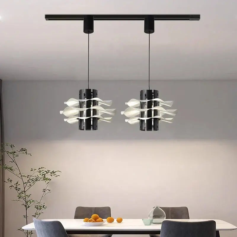 Two modern black pendant lamps with white petal glass shades hang from a track in a designer restaurant pendant decorbites setup