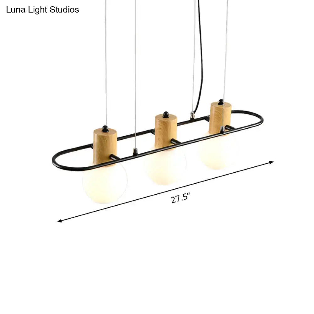 Modern black orb island pendant light with frosted glass hanging shades and natural wood accents in a sleek frame