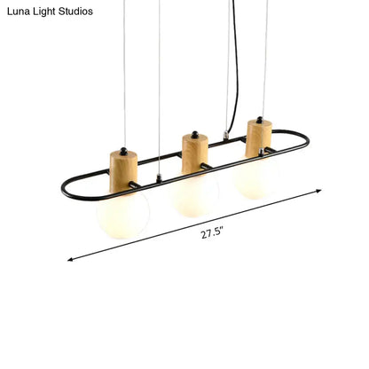 Modern black orb island pendant light with frosted glass hanging shades and natural wood accents in a sleek frame