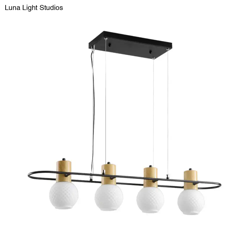 Modern black orb island pendant light with four frosted glass globes and gold-toned cylindrical accents