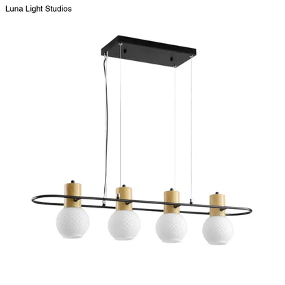 Modern black orb island pendant light with four frosted glass globes and gold-toned cylindrical accents