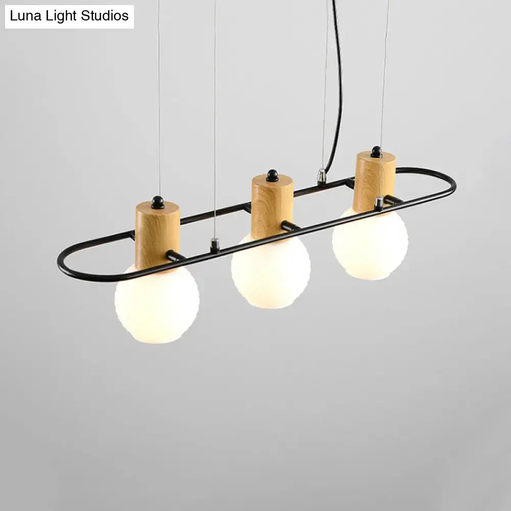 Modern black orb island pendant light with three frosted glass globes on wooden bases and black metal rods hanging