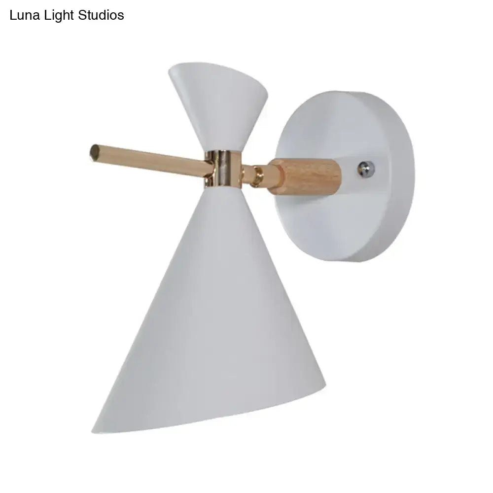 White conical wall sconce with brass accent and light wood arm featuring modern black angle shade for bedroom lighting