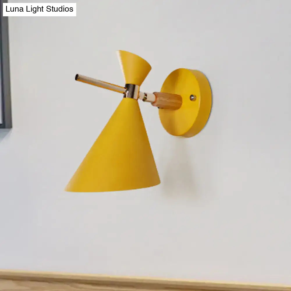 Bright yellow conical wall sconce with wooden arm and metal joint featuring modern angle shade for bedroom lighting