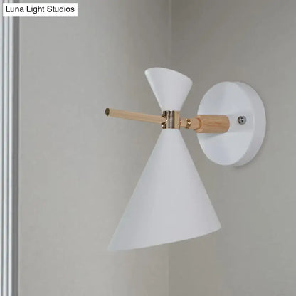 White conical wall sconce with wooden arm and brass accents featuring modern black angle shade for bedroom lighting