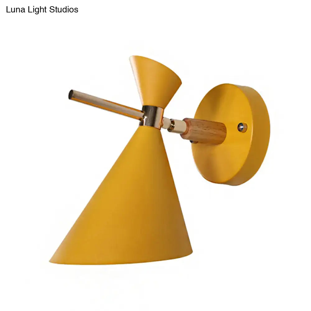 Vibrant mustard-yellow conical wall sconce with wooden arm and metallic accents featuring modern black angle shade design
