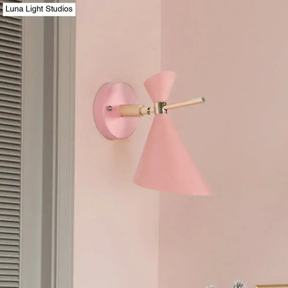 Modern black angle shade wall sconce with wood arm and pink conical matte wall sconce with brass hardware for bedroom lighting