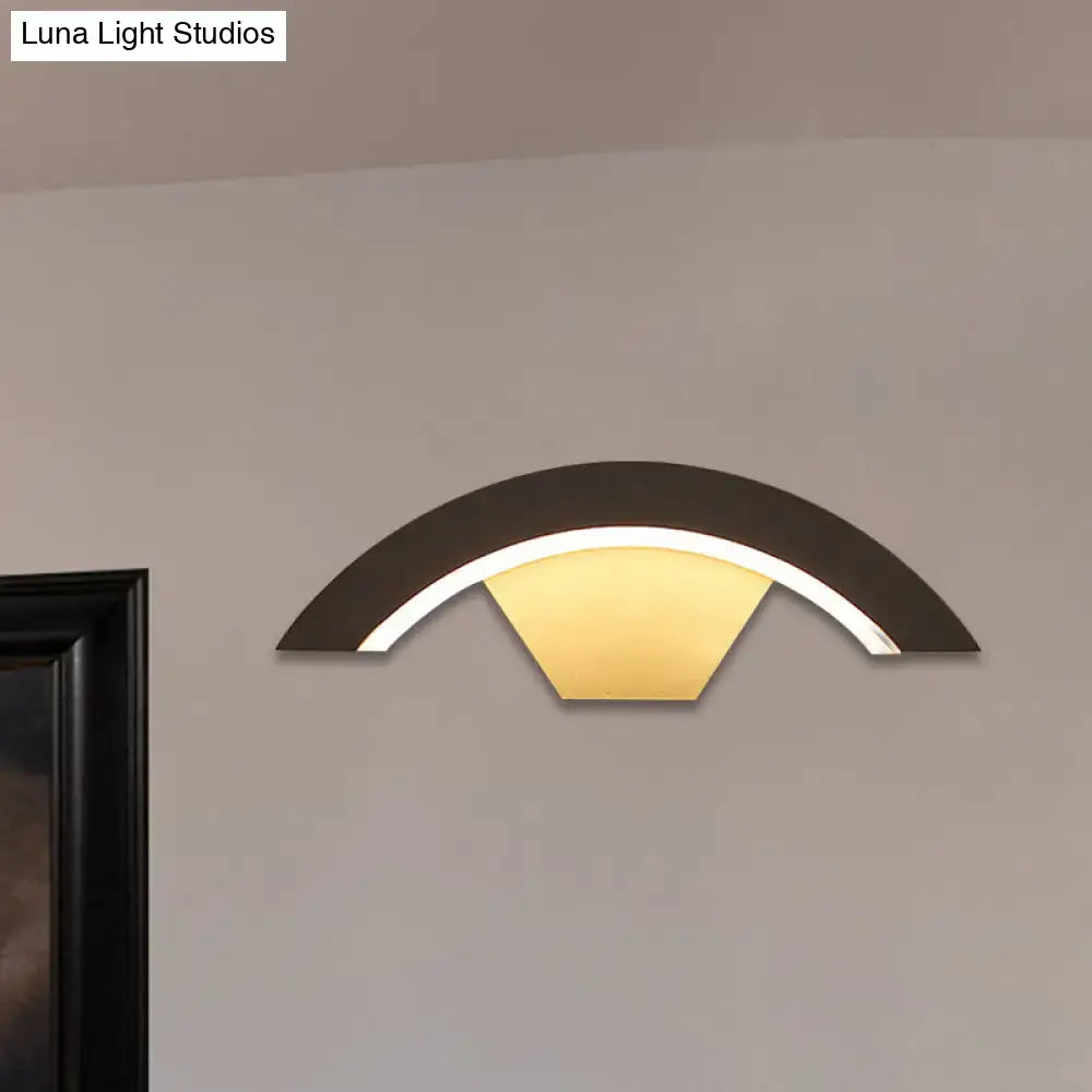 Modern black arc wall sconce with warm yellow integrated led light designed for bedroom wall sconce lighting