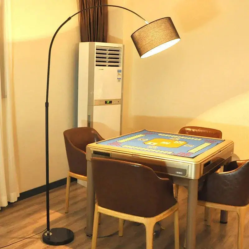 A sleek modern black arched led floor lamp with a textured beige fabric shade for living room use