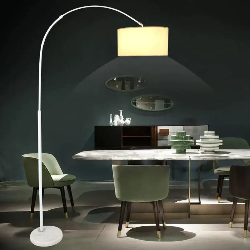 White arched led floor lamp with a cylindrical beige fabric shade and marble base for modern living room use