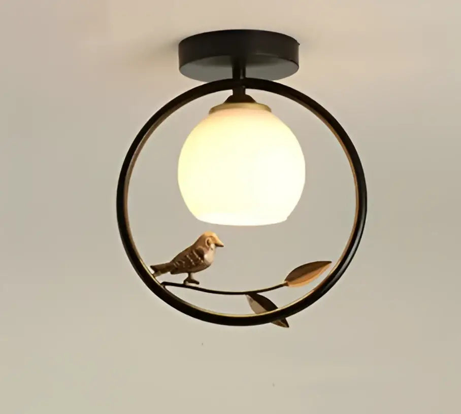 Modern black metal circular ceiling light fixture with warm white globe bulb and bird figurine for corridor entrance