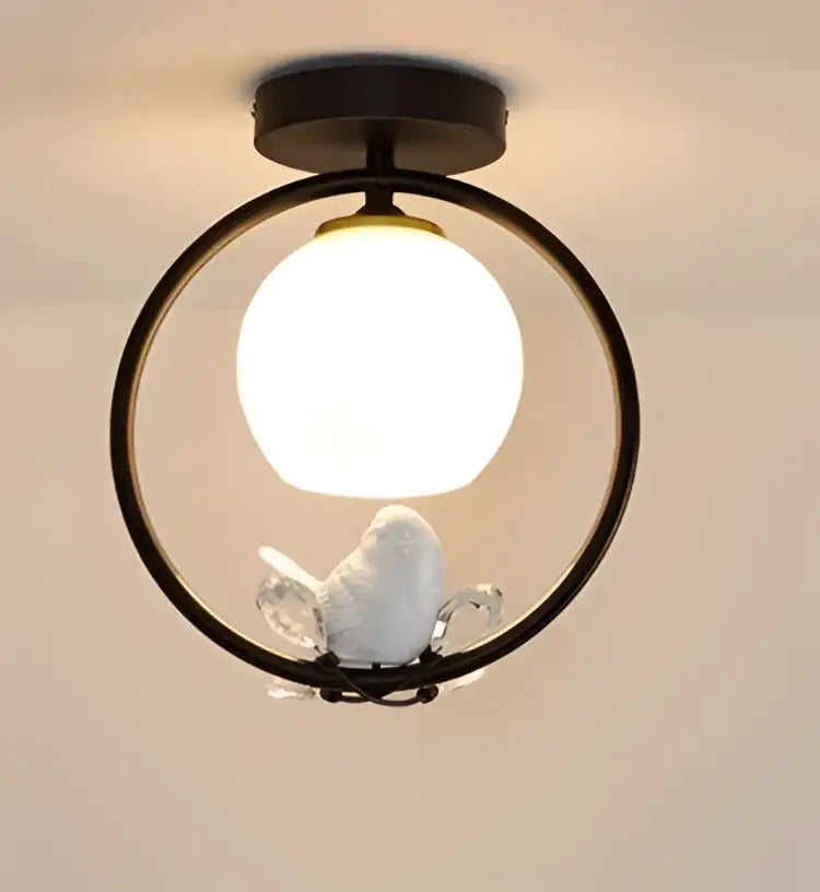 Modern black ceiling light fixture with white ceramic bird figurine and frosted globe bulb for corridor entrance