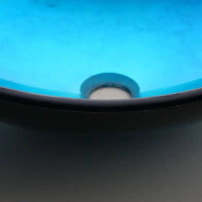 Modern black and blue glass vessel sink basin tap set with a blue ceramic sink, black rim, and metallic drain