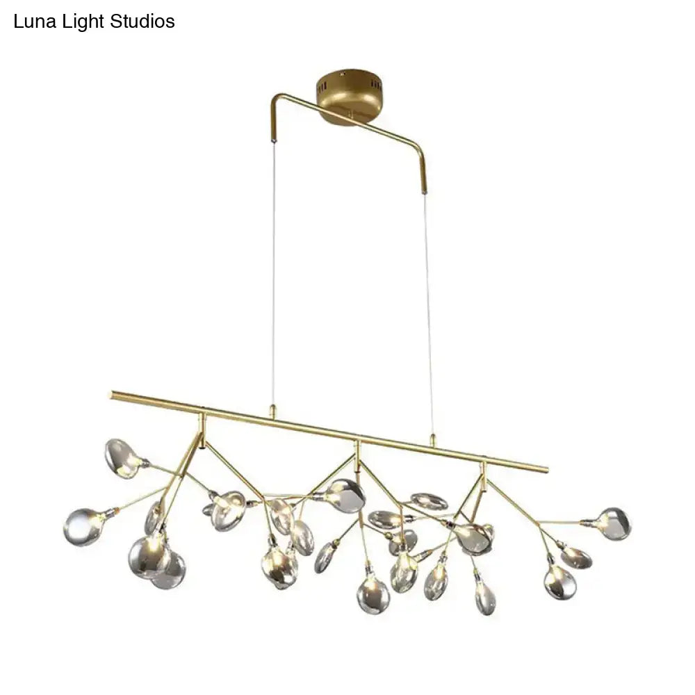 Modern black branching chandelier with brass-toned frame and clear glass teardrop pendants for dining room lighting