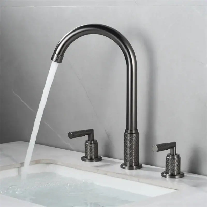 Modern black brass basin faucet with textured diamond-patterned handles mounted on white marble sink decorbites black brass