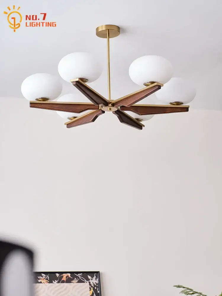 Modern black and brass cream wood led chandelier with gold-toned starburst design and six frosted glass globe shades for decorbites cream wood decor