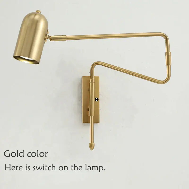 Gold-colored brass wall lamp with decorbites adjustable long-arm and cylindrical shade for bedroom lighting