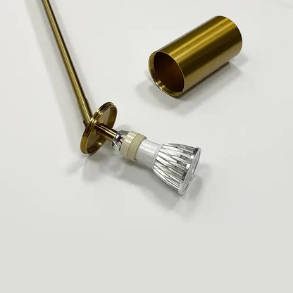 Gold-finished gu10 led bulb with cylindrical brass housing and ridged lens in modern black and brass directional pendant light