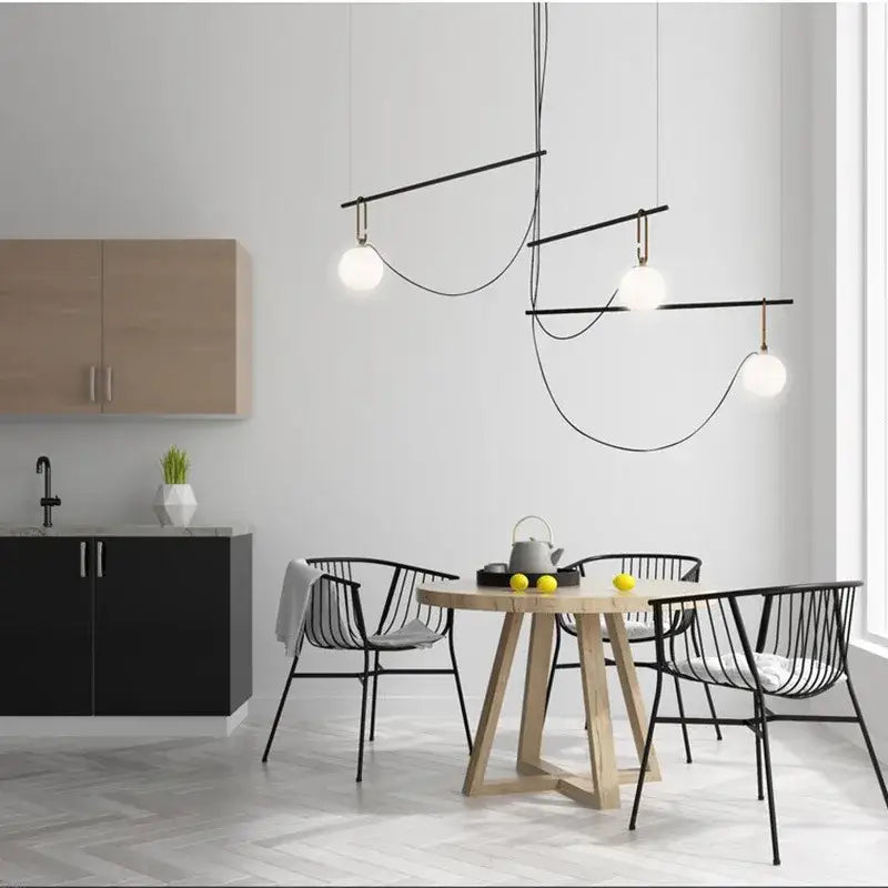 Modern black and brass pendant light with three white glass ball bulbs suspended by curved wires for bedroom decorbites decor