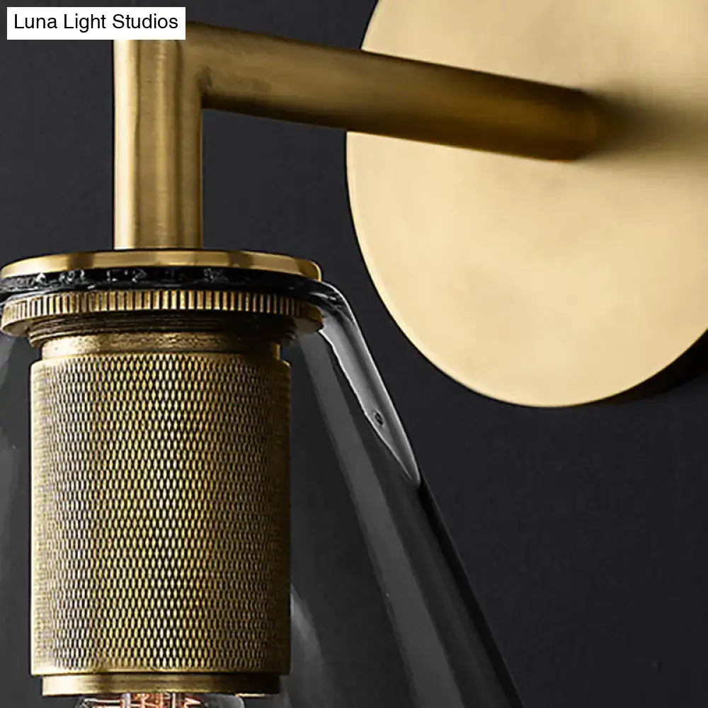 Modern brass-finished wall light with textured cylindrical shade and clear glass diffuser for direct wired electric use