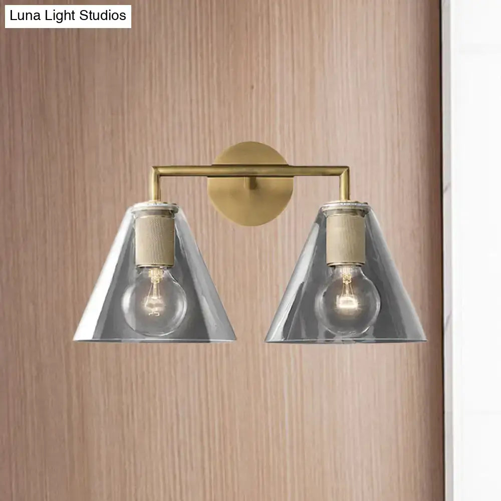 Brass-finished modern wall light with two clear glass cones and wooden accents direct wired electric for bedroom use
