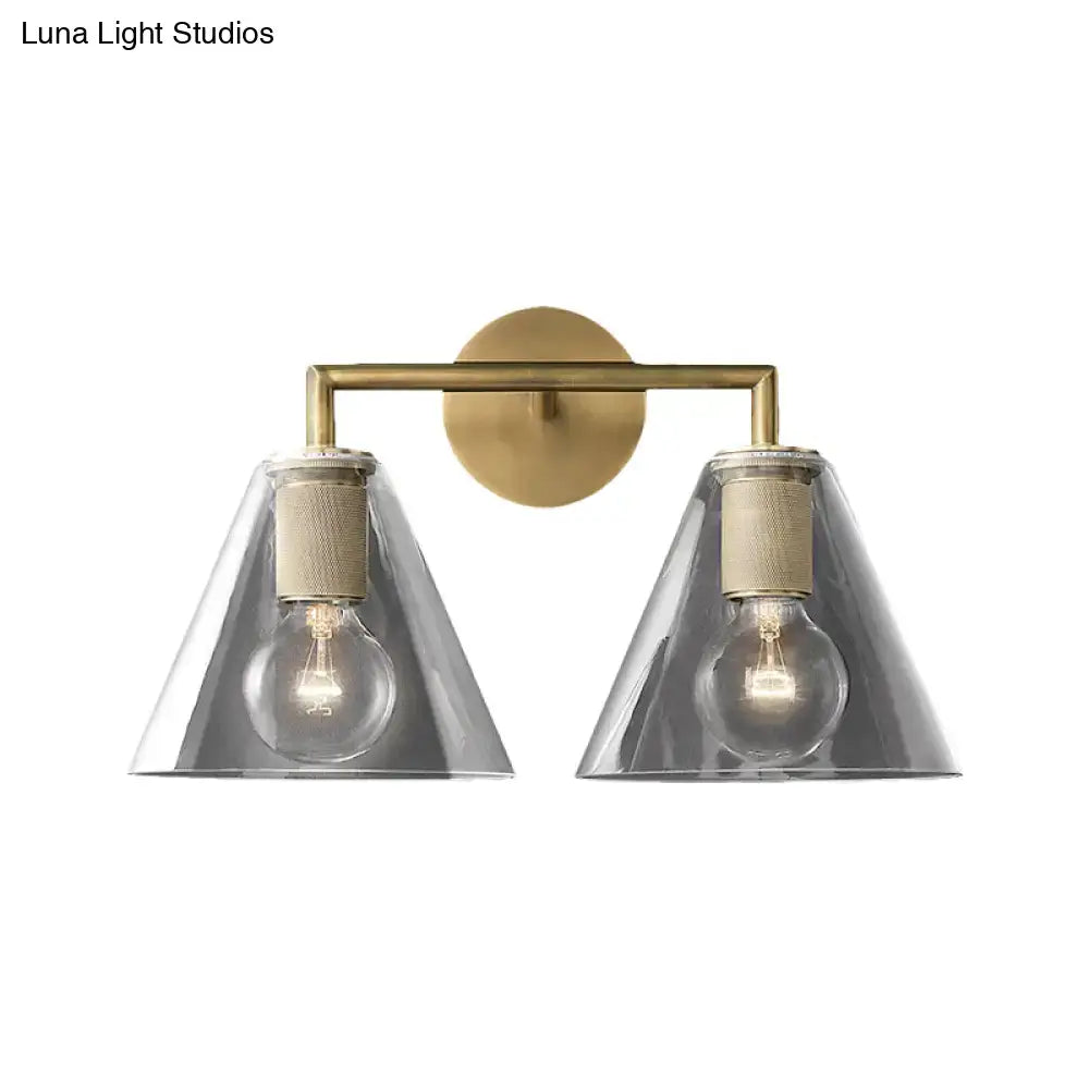 Brass-finished modern wall light with two conical smoked glass shades and exposed filament bulbs direct wired electric