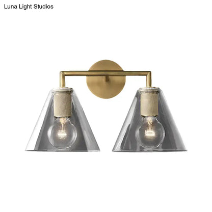 Brass-finished modern wall light with two conical smoked glass shades and exposed filament bulbs direct wired electric