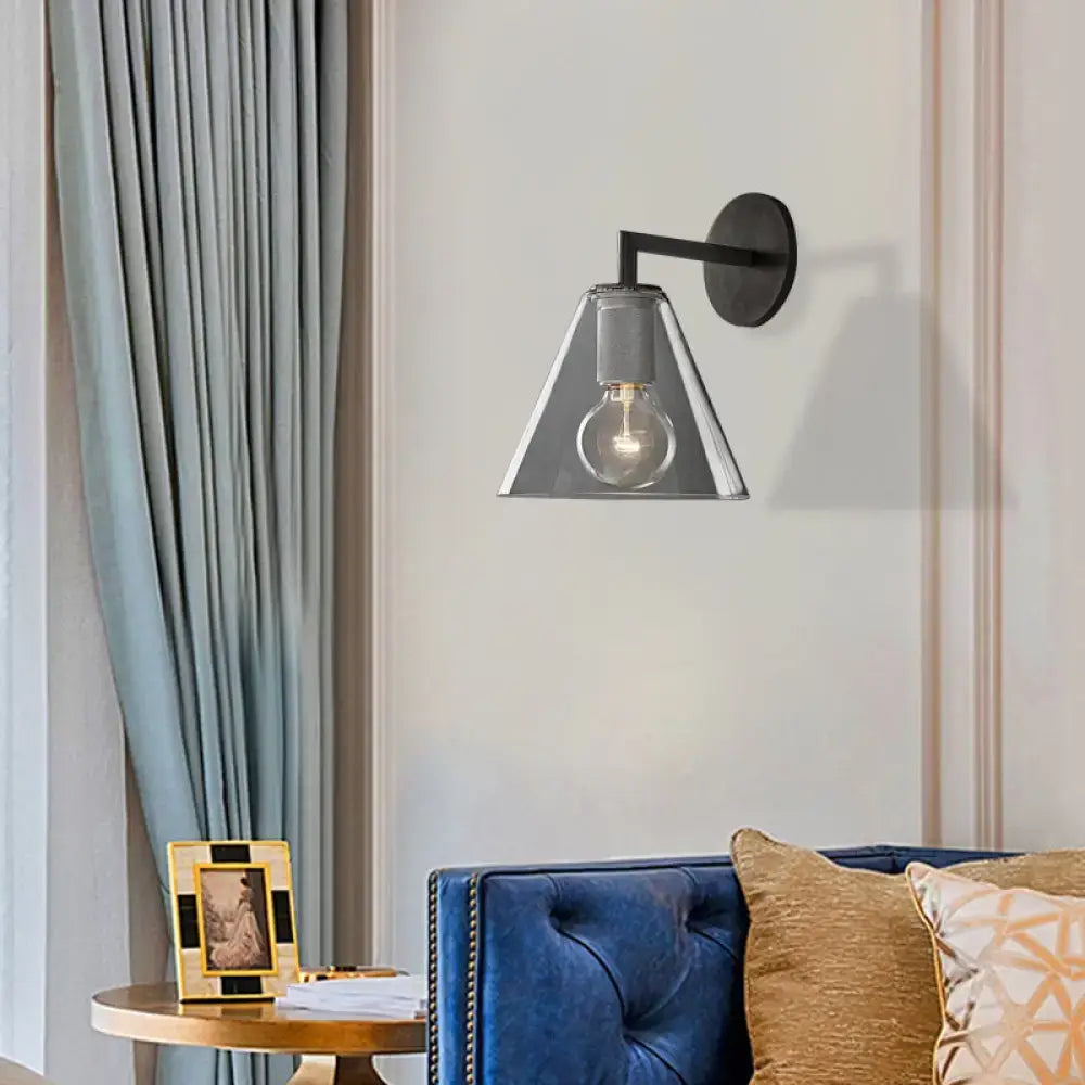 Modern black metal wall light with clear glass conical shade and exposed bulb, direct wired electric for bedroom use
