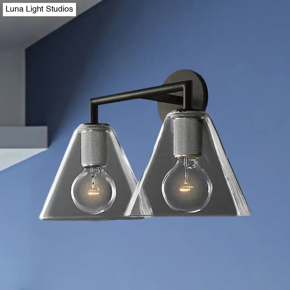 Modern black metal wall light with brass accents and clear glass cone shades featuring exposed filament bulbs direct wired electric