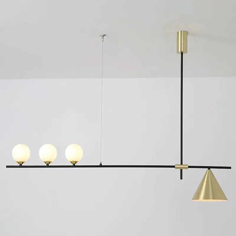 Modern black and brass linear chandelier with spherical white glass bulbs and a conical brass shade for dining room use