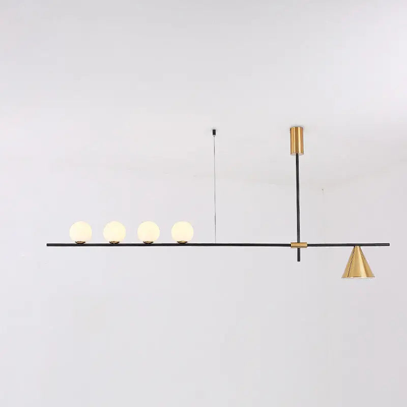 Modern black and brass linear chandelier with spherical white glass frosted globes on a sleek minimalist bar
