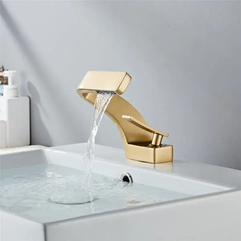 Modern black and brushed gold decorbites basin faucet with sleek angular design and waterfall spout for bathroom use