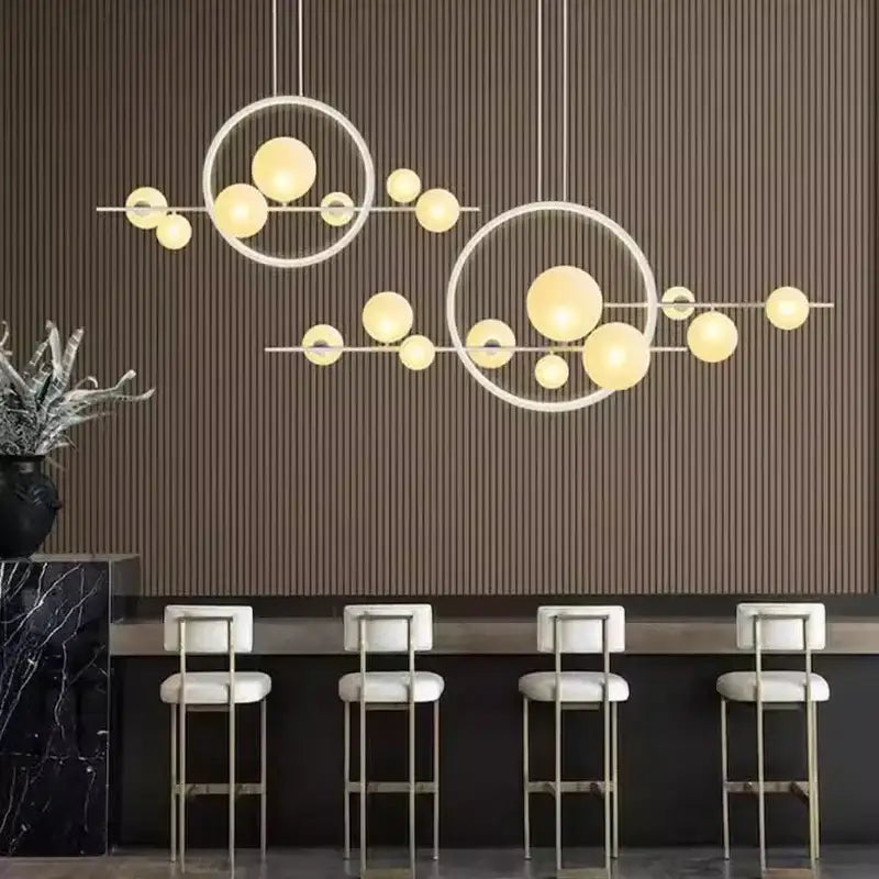 Modern black bubble glass pendant light with interconnected circular frames and warm yellow spherical bulbs decorbites bubble glass