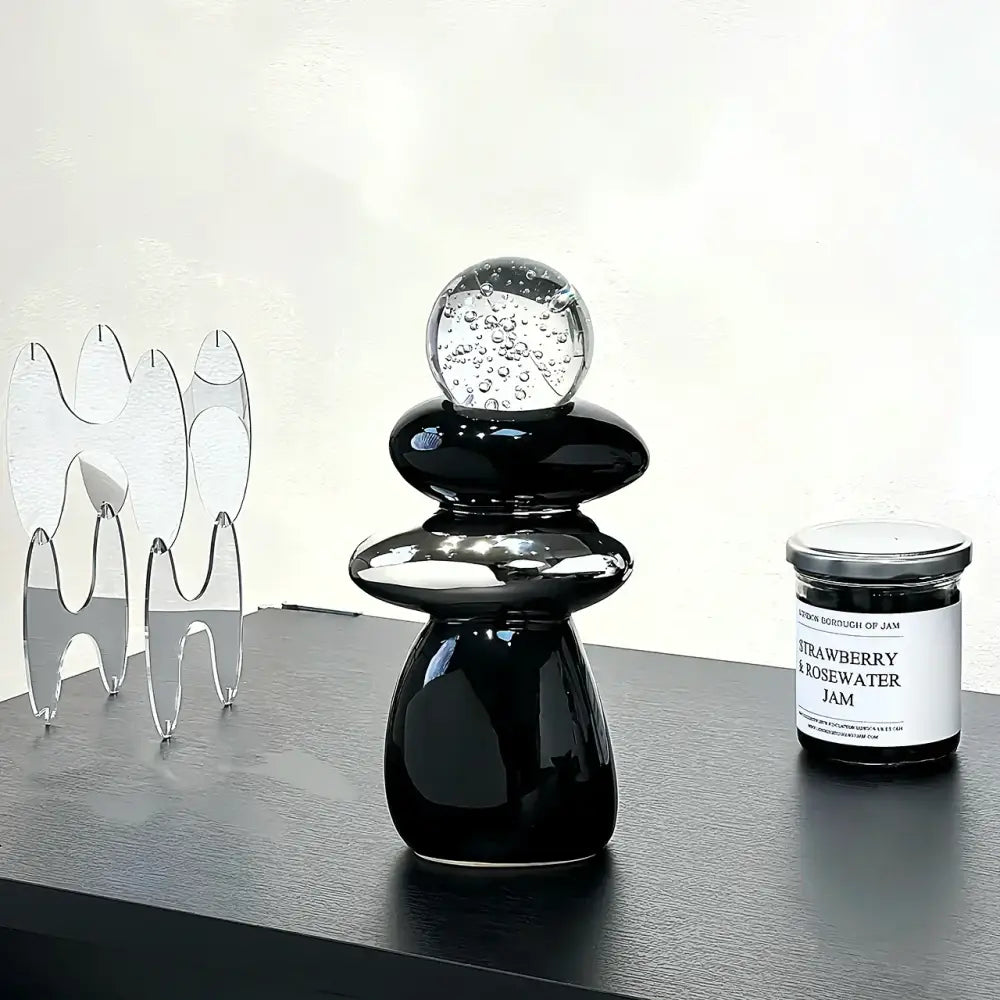 Shiny black ceramic decorative crystal ball statue with stacked rounded tiers and clear glass orb for living room decor