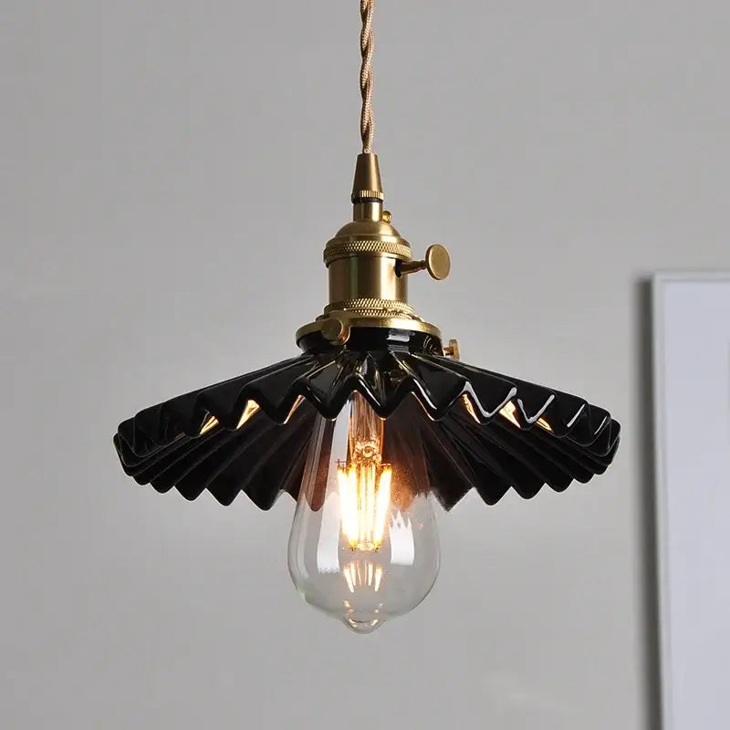 Modern black ceramic led pendant light with brass detail featuring a fan-shaped design and clear glass bulb by decorbites