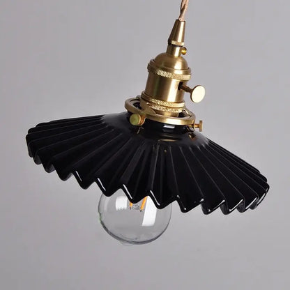 Modern black ceramic led pendant light with brass detail featuring a fan-shaped design and exposed bulb by decorbites
