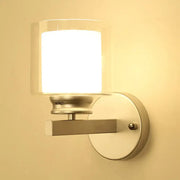 Modern black and chrome wall mounted clear glass sconce with cylindrical shade for bedroom lighting