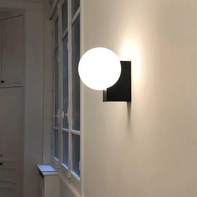 Modern black and chrome glass ball wall sconce with glowing white spherical shade for bedroom decorbites glass ball lighting