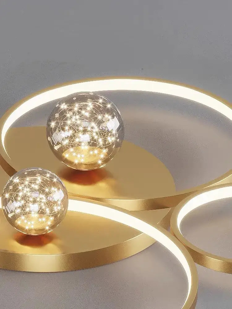 Modern black and chrome decorbites gypsophila chandelier with gold-toned led light fixtures and star-patterned glowing orbs