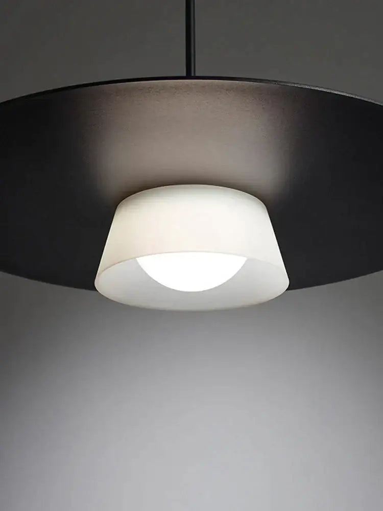 Modern black pendant light with matte circular shade and frosted glass for decorbites circular coffee shop decor