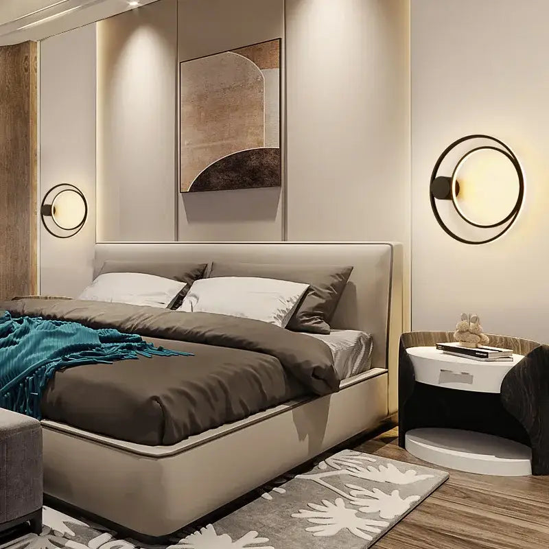 Modern beige upholstered bed with matching headboard under a sleek black circular led wall lamp minimalist sconce