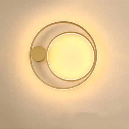 Modern gold-toned circular led wall lamp with concentric rings and warm diffused glow for minimalist bedroom decor