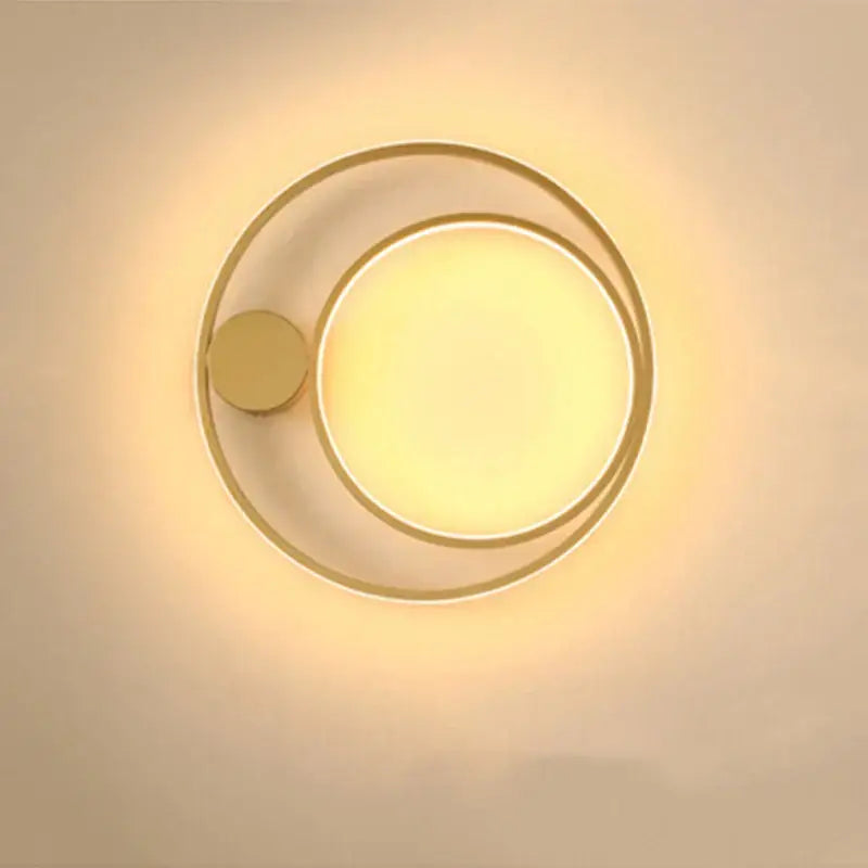 Modern gold-toned circular led wall lamp with concentric rings and warm diffused glow for minimalist bedroom decor