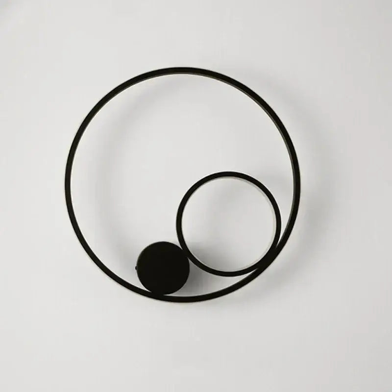 Modern black circular led wall lamp with minimalist concentric rings and spherical element for bedroom sconce