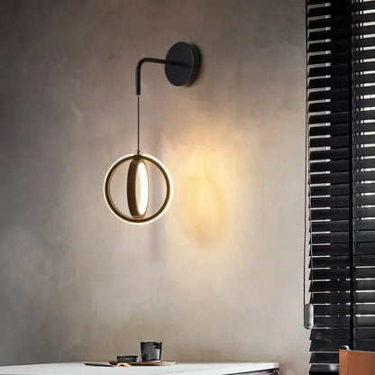 Modern black circular wall sconce light with a glowing ring design emitting warm light for bedroom use