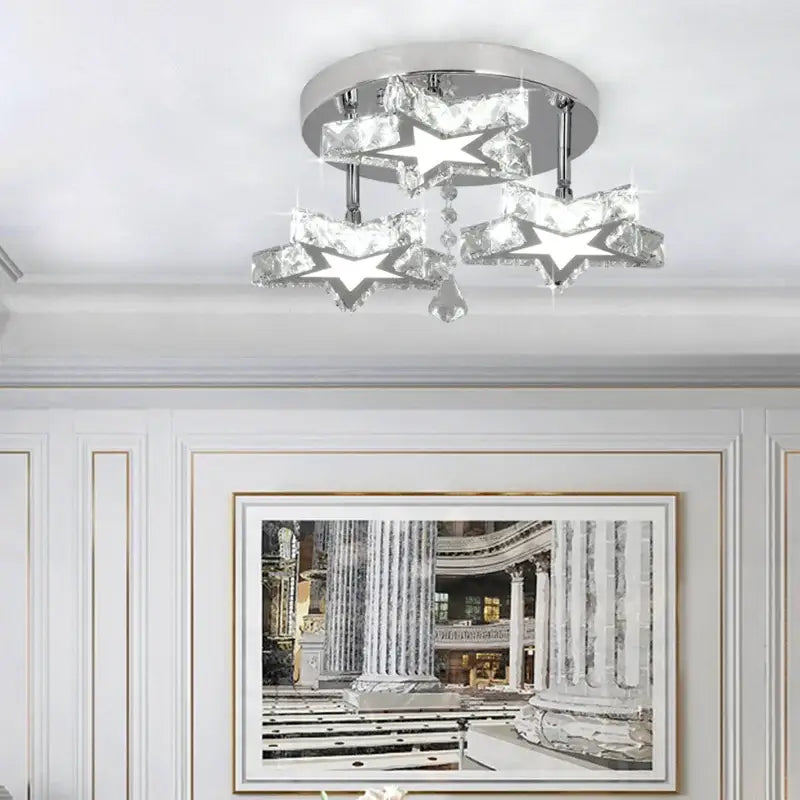 Modern black and clear crystal LED ceiling chandelier with three sparkling star-shaped crystals on a chrome base