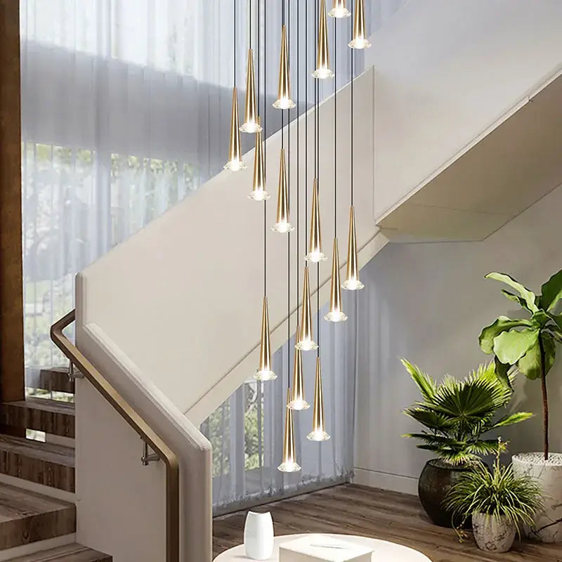 A modern gold-toned lighting fixture with slender tapered cones and clear glass decorbites crystal led accents for stair use