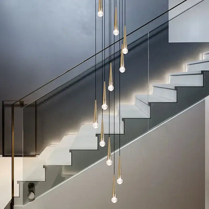 Modern gold-toned decorbites crystal led pendant lights with clear glass globes cascade above staircase